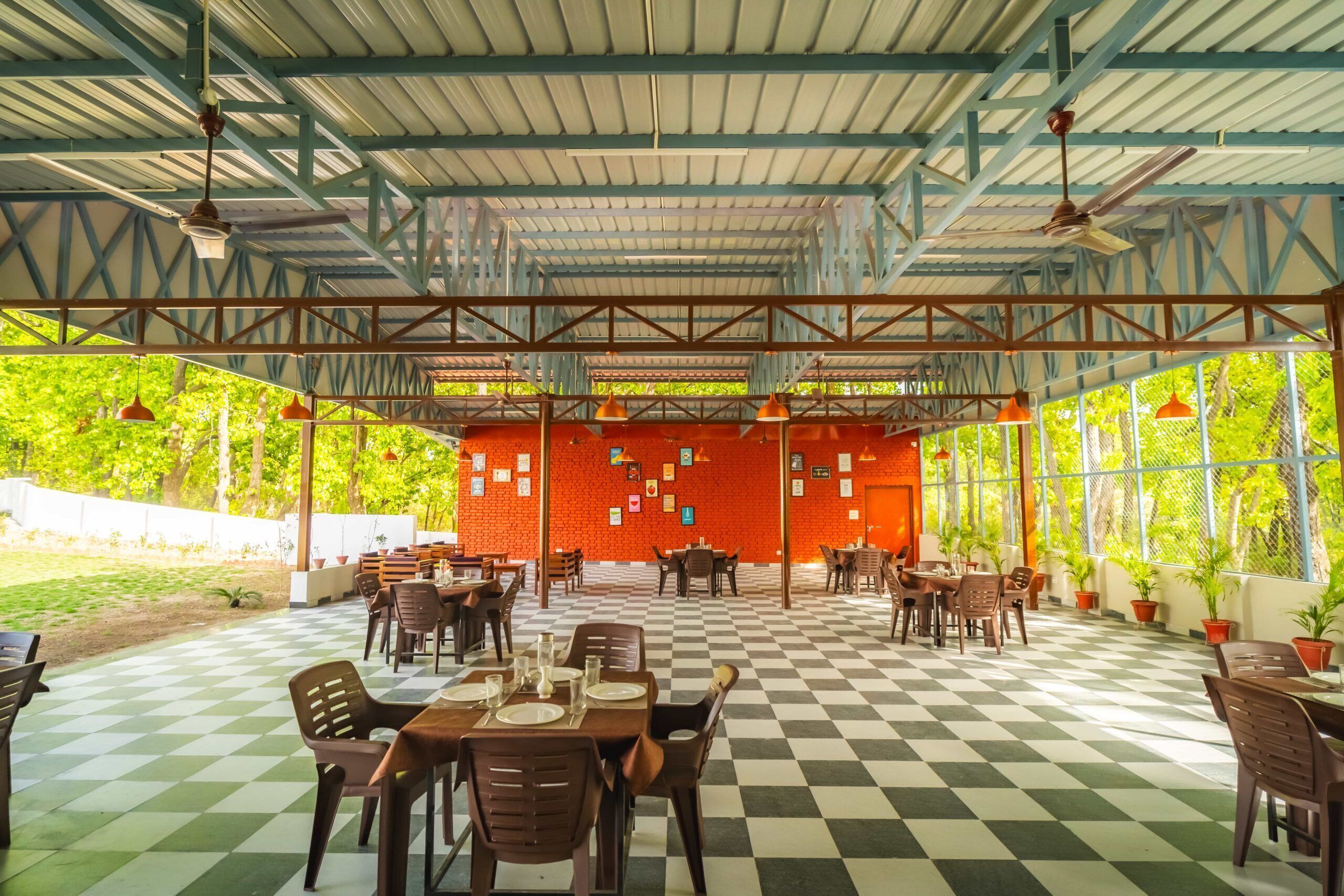 An outdoor dining area with checkered flooring, tables, chairs, and potted plants.