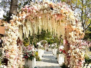 An outdoor floral archway with a pathway leading through it. - Pristine Woods (Vikasnagar)