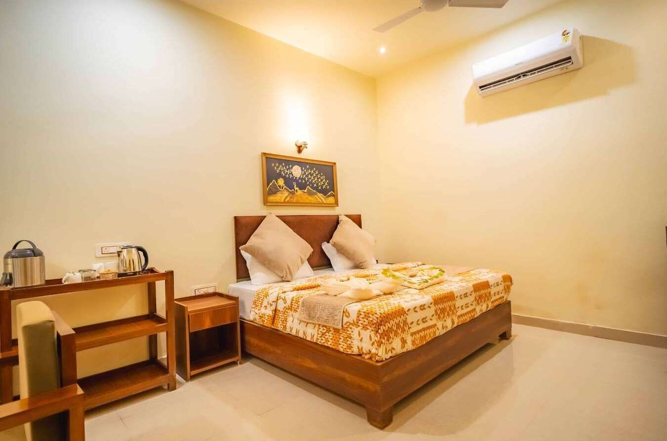 Un dormitorio ordenado con cama, mesita de noche y aire acondicionado de pared.
