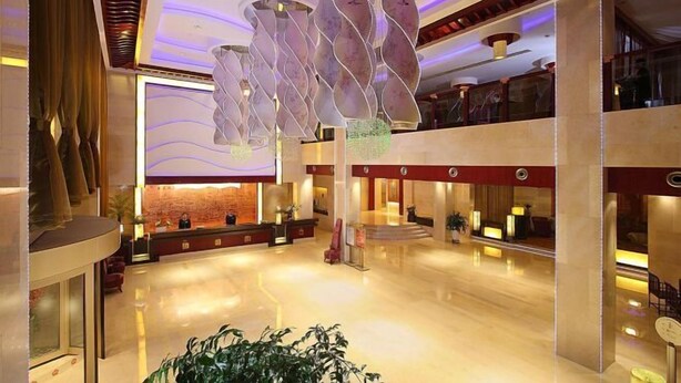 A spacious lobby with a modern design, featuring a reception desk, seating areas, and a decorative ceiling. - Meiyuan Hotel (Jiashan)