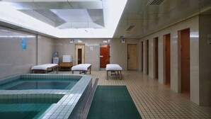 A hotel room with a large indoor pool, a small table, and a chair. - Meiyuan Hotel (Jiashan)