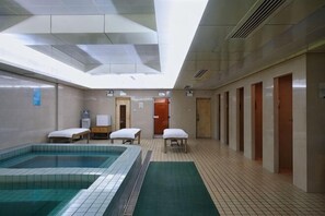 A hotel room with a large indoor pool, a small table, and a chair. - Meiyuan Hotel (Jiashan)