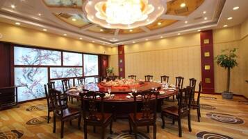 A conference room with a round table, multiple chairs, and a chandelier.