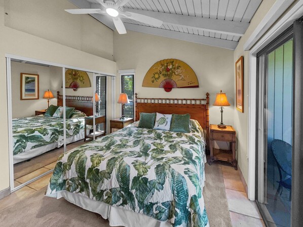 A hotel room with a large bed, two bedside tables, a ceiling fan, and a large window. - Oceanview Serenity Meets Modern Comfort: Discover Wailea Ekolu #402 (Wailea, Maui)