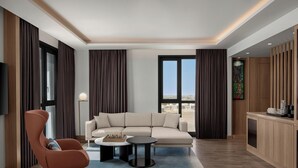 A modern living room with a sofa, a chair, a coffee table, and a TV. - Courtyard By Marriott Dakar Diamniadio (Diamniadio)