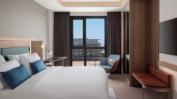 Une chambre d’hôtel moderne équipée d’un grand lit, d’un bureau, d’une chaise et d’une télévision.
