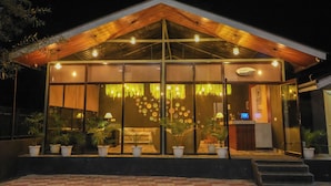 Ein modernes Gebäude mit Holzdach, großen Glasfenstern und einer Rezeption.