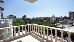 A balcony with a white balustrade overlooking a residential area with various buildings and greenery. - Avsallar Kepenek Village (Alanya)