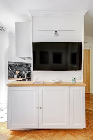 Enjoy cooking in this well-equipped kitchen with a large TV, sink, and ample storage.