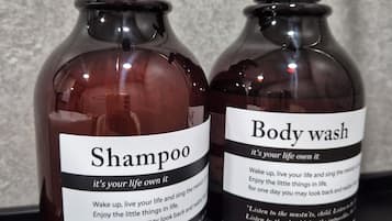 Two bottles of shampoo and body wash with pump dispensers on a countertop.