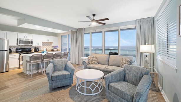 A modern kitchen with a dining area, a living room with a view, and a ceiling fan. - Silver Beach 206 by Liquid Life (Orange Beach)