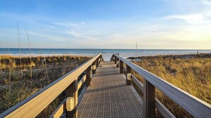A wooden boardwalk leading to the beach with a clear sky. - Silver Beach 206 by Liquid Life (Orange Beach)
