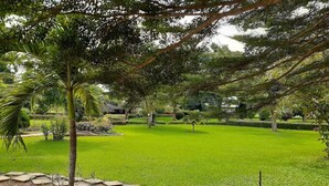 A well-maintained grassy area with stone borders and trees, likely part of a park or garden setting. - Crown City Resorts  (Agbara)