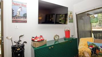 A room with a green cabinet, a clock, and a poster on the wall.