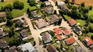 Vue aérienne d’un quartier résidentiel avec des maisons, des rues et des espaces verts.