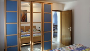 Une chambre à coucher comprenant un lit, une armoire à porte coulissante et un bureau avec une chaise.