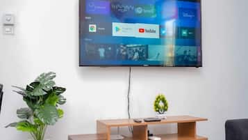 Deluxe Apartment, City View | Living area | 24-inch Smart TV with digital channels