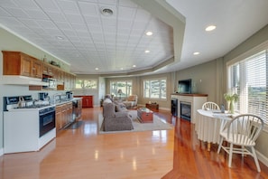 Enjoy a warm and inviting living area with a large open kitchen and cozy seating area featuring a fireplace.