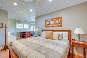 Cozy retreat with a large bed, wooden headboard, and a framed artwork above.