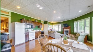 A spacious kitchen with wooden cabinets and a dining area with a round table and chairs. - Amish Country Getaway w/ Pastoral Views! (Millersburg)