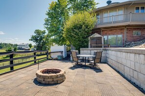 A patio area with a fire pit, outdoor furniture, and a view of a residential building. - Panoramic Views: Hillside Millersburg Studio (Millersburg)