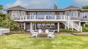 Ein großes, zweistöckiges Haus mit Balkon, Whirlpool und Feuerstelle im Garten.