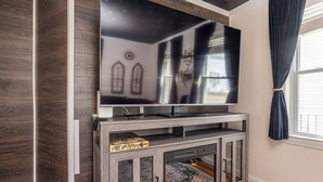 A modern living room with a large flat-screen TV mounted on a wooden console table.