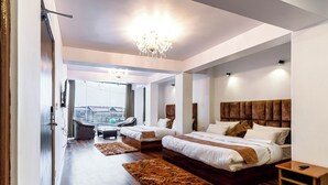 Una camera da letto moderna con due letti, un lampadario e vista sulla città.