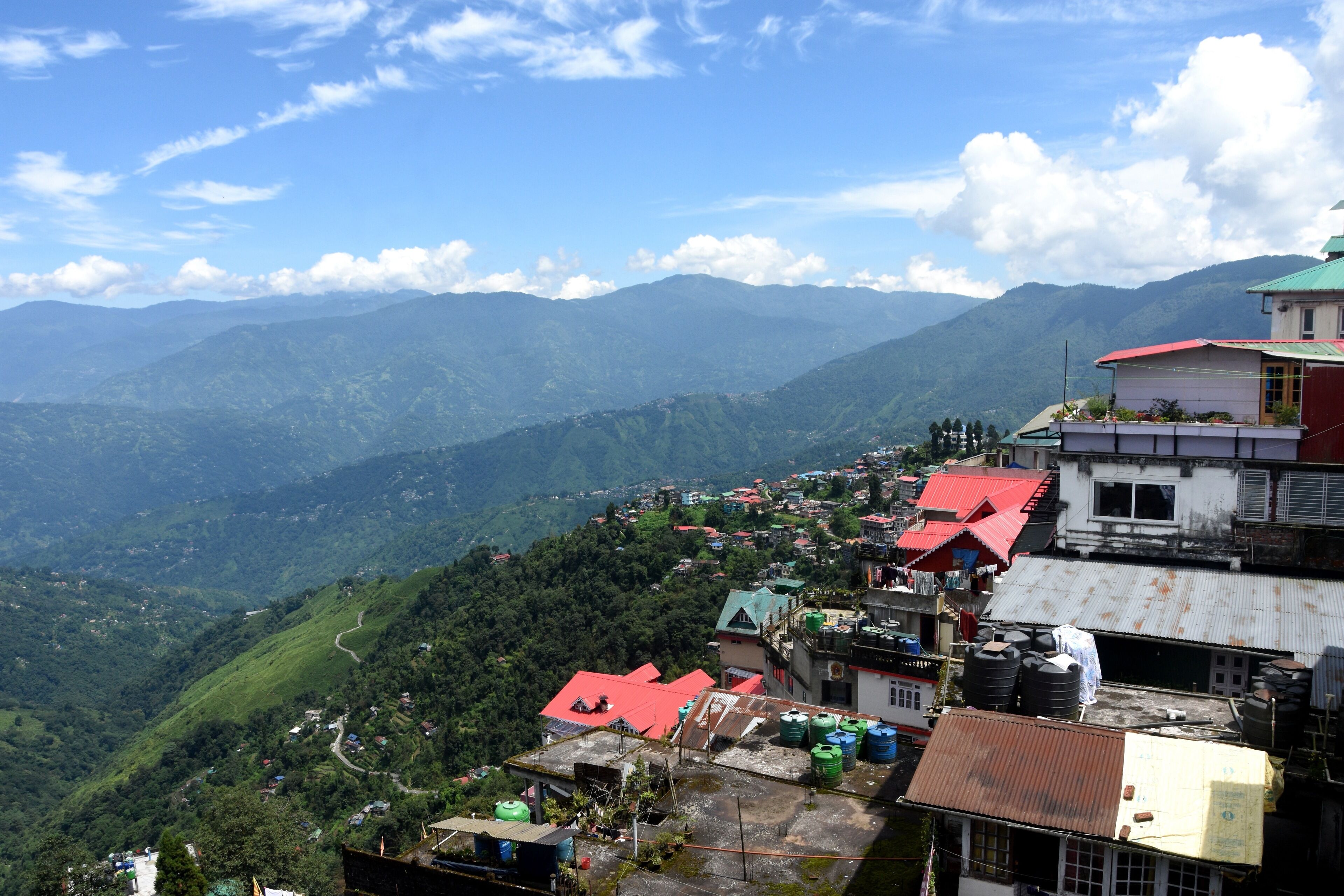 A mountainous village with terraced houses and a winding road.