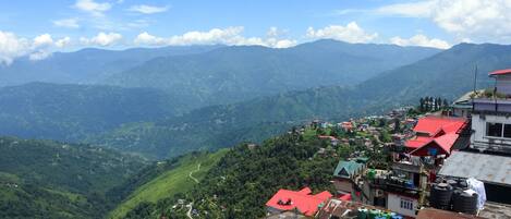 A mountainous village with terraced houses and a winding road.