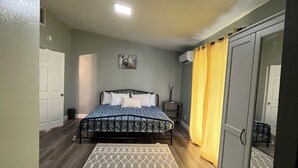 Ein Schlafzimmer mit einem Bett, einem Kleiderschrank, einem Teppich und einem Bild an der Wand.
