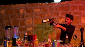 A person pouring a drink at a bar with various bottles and glasses. - Hotel Sia Luxury Resort (Jaisalmer)