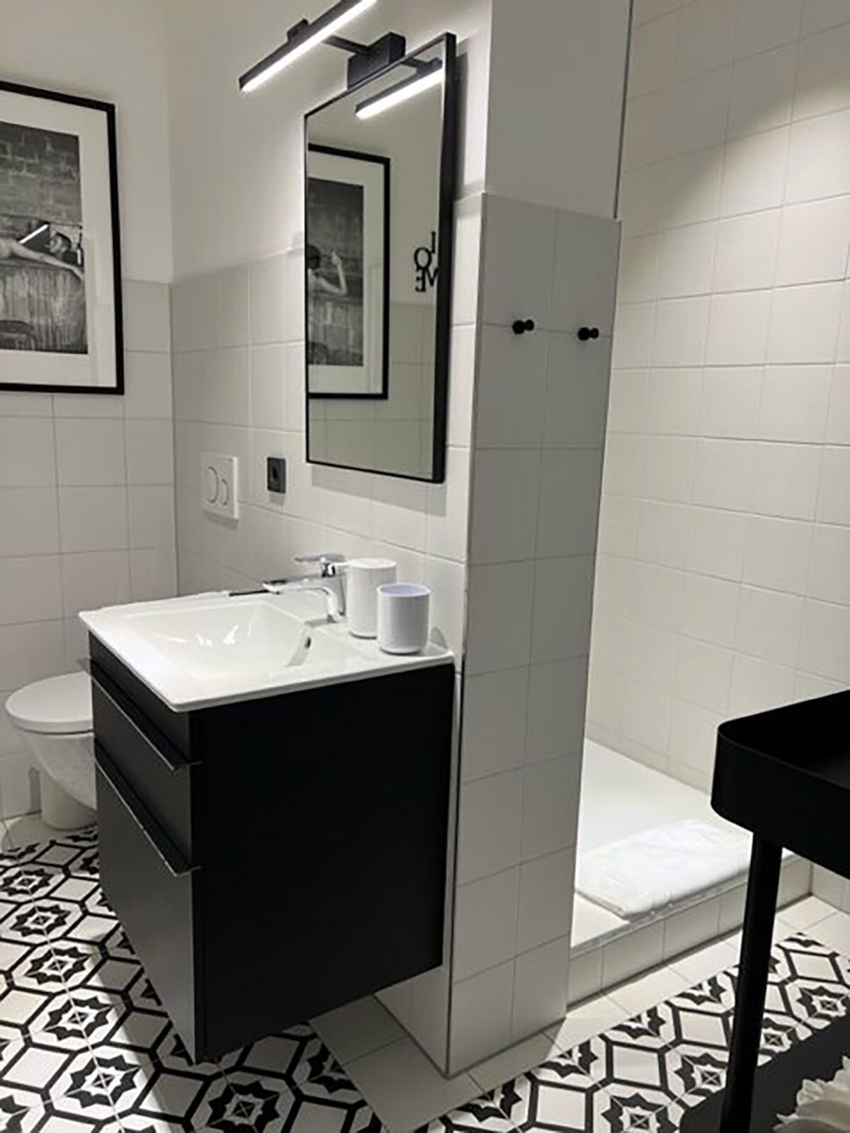 Een moderne badkamer met een groot wastafel, een spiegel, een toilet en een douche.