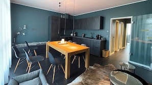 A modern living space with a dining area, a kitchen, and a seating area. - InkBlue Apartment (Heidenau)