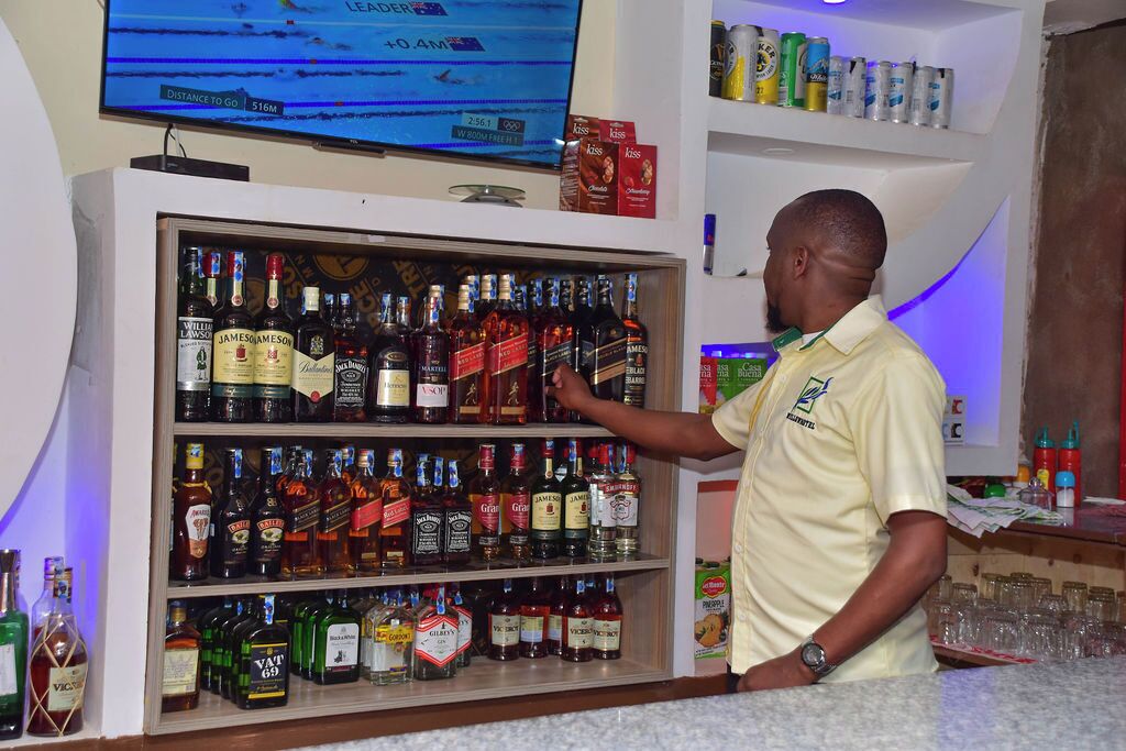 A bar area with shelves stocked with various liquor bottles.