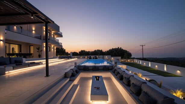 A modern outdoor pool area with a rectangular pool, built-in seating, and ambient lighting.