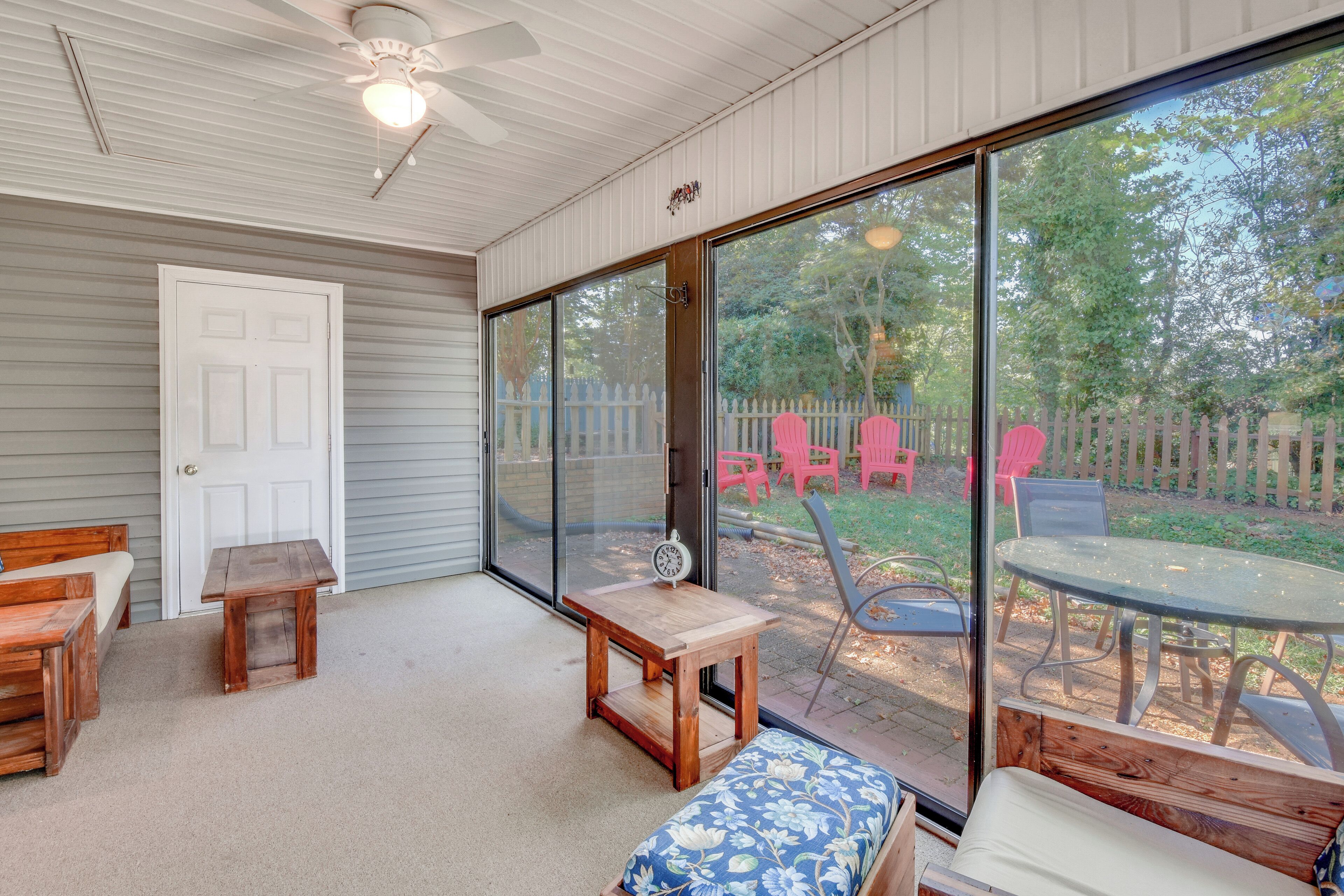 A covered patio area with a wooden bench, a small table, and a dining table with chairs.