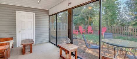 A covered patio area with a wooden bench, a small table, and a dining table with chairs.
