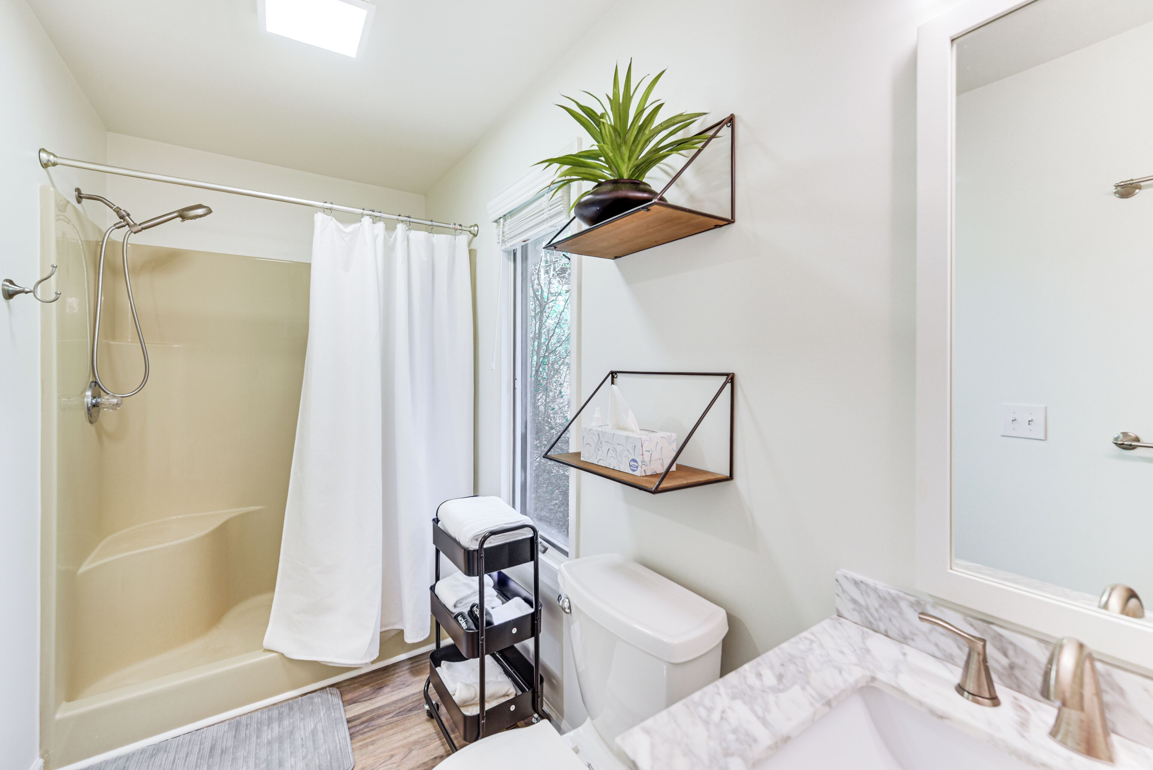 A modern bathroom with a shower, toilet, and sink.