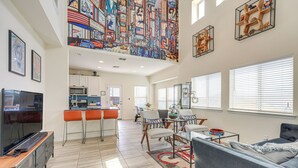 A spacious living area with a kitchen, dining space, and a large TV. - Large Fenced Yard: Family-friendly Kyle Home (Kyle)