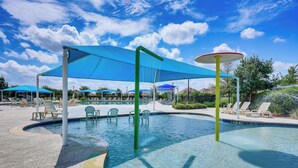 A swimming pool with blue canopies, lounge chairs, and a clear sky. - Large Fenced Yard: Family-friendly Kyle Home (Kyle)