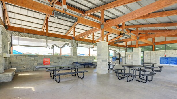 An indoor pavilion with picnic tables and stone pillars. - Large Fenced Yard: Family-friendly Kyle Home (Kyle)