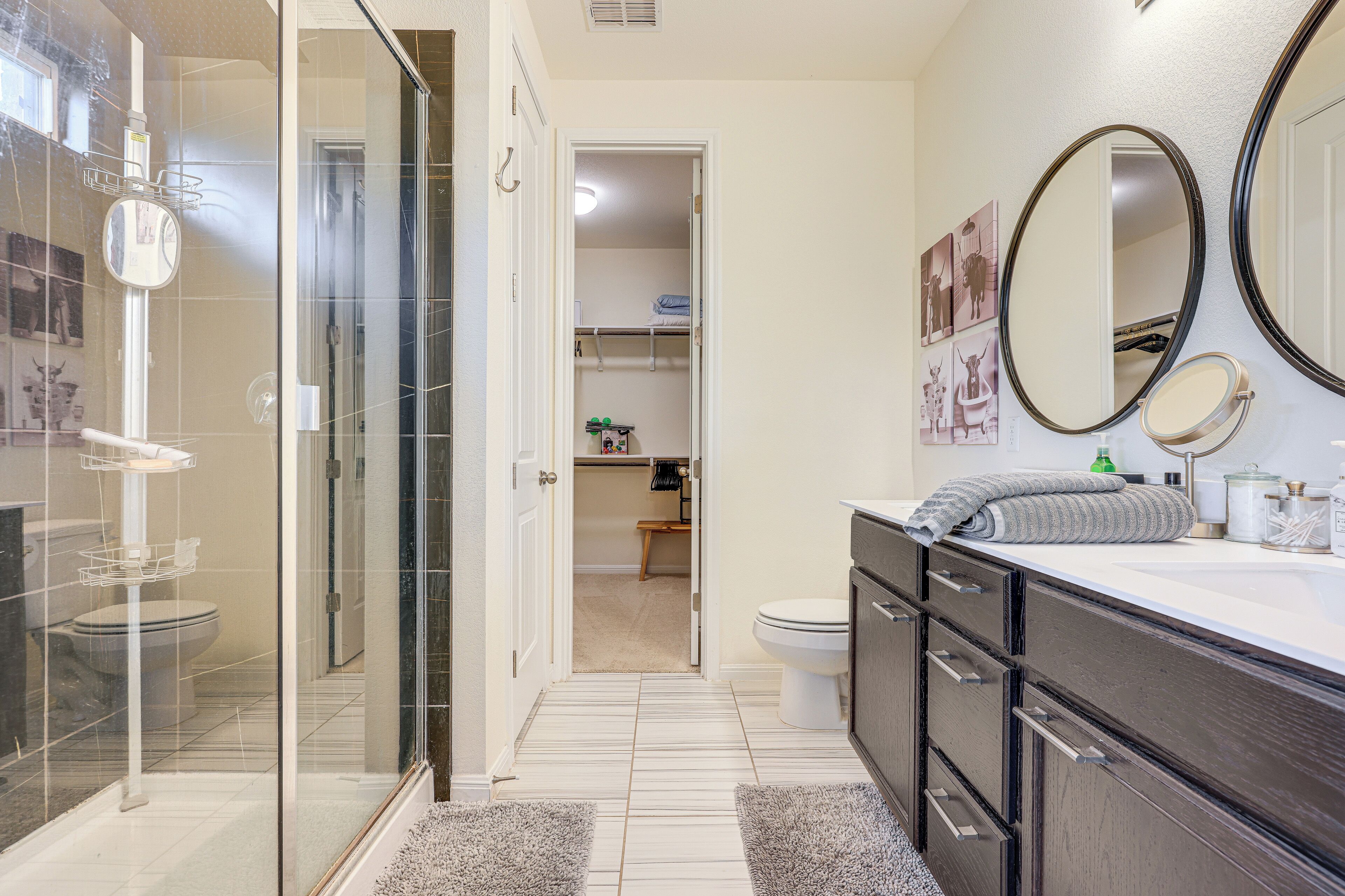 A modern bathroom with a glass shower enclosure, a toilet, and a vanity with a mirror.