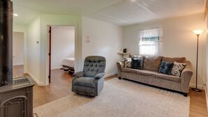 Una sala de estar con chimenea, un sofá, una silla y una lámpara.