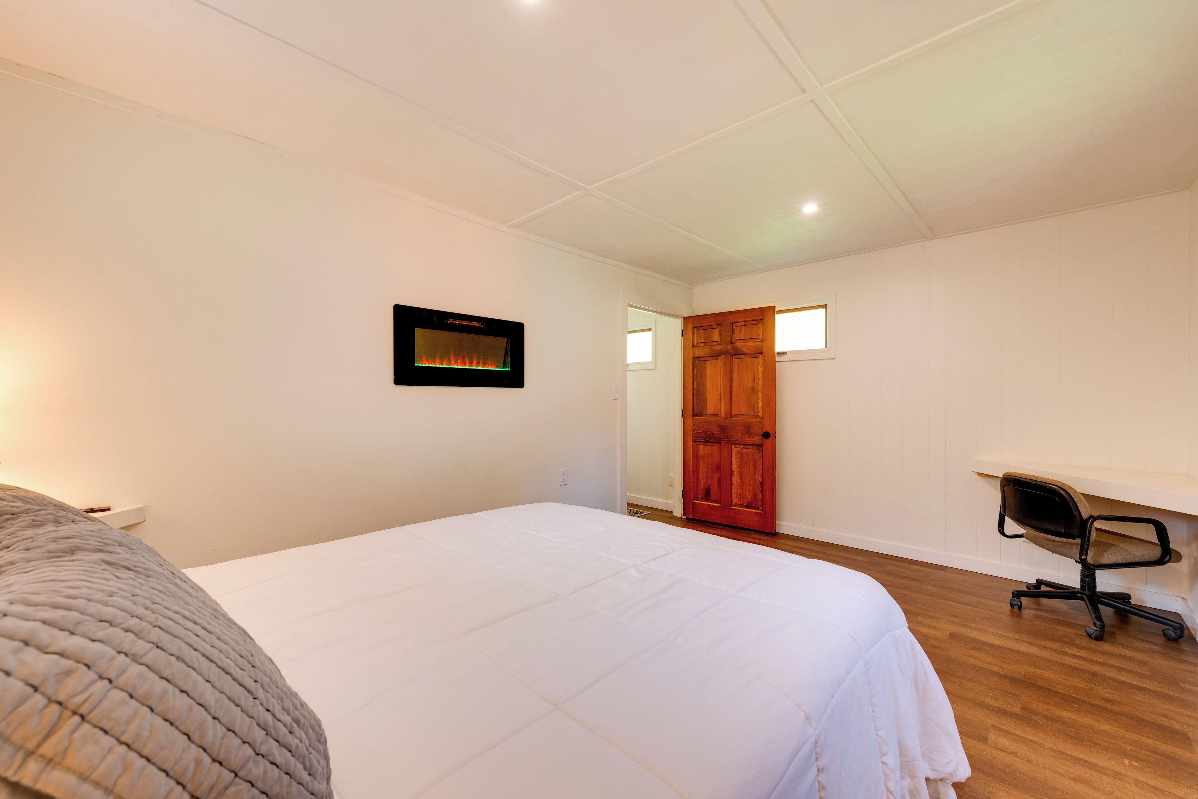 A bedroom with a bed, a desk, and a chair.