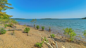 A pebbled beach with sparse vegetation and a clear blue sky. - Spacious Heber Springs Home - Easy Marina Access! (Heber Springs)