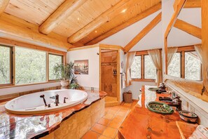 A spacious bathroom with a large bathtub, wooden beams, and large windows. - Scenic Payson Cabin! Fireplace + Wraparound Patio (Payson)