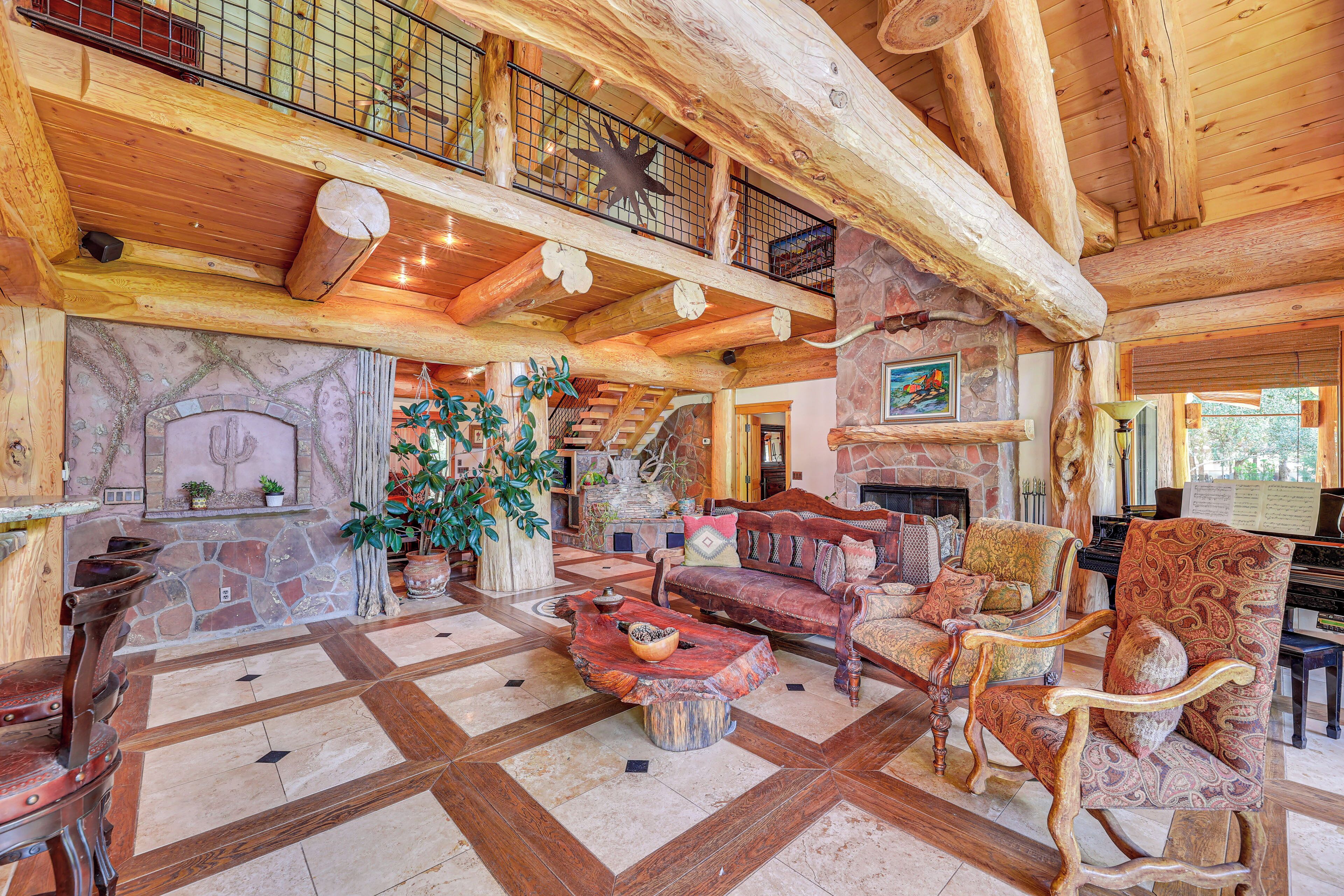 A spacious lobby with a stone fireplace, wooden furniture, and a piano.