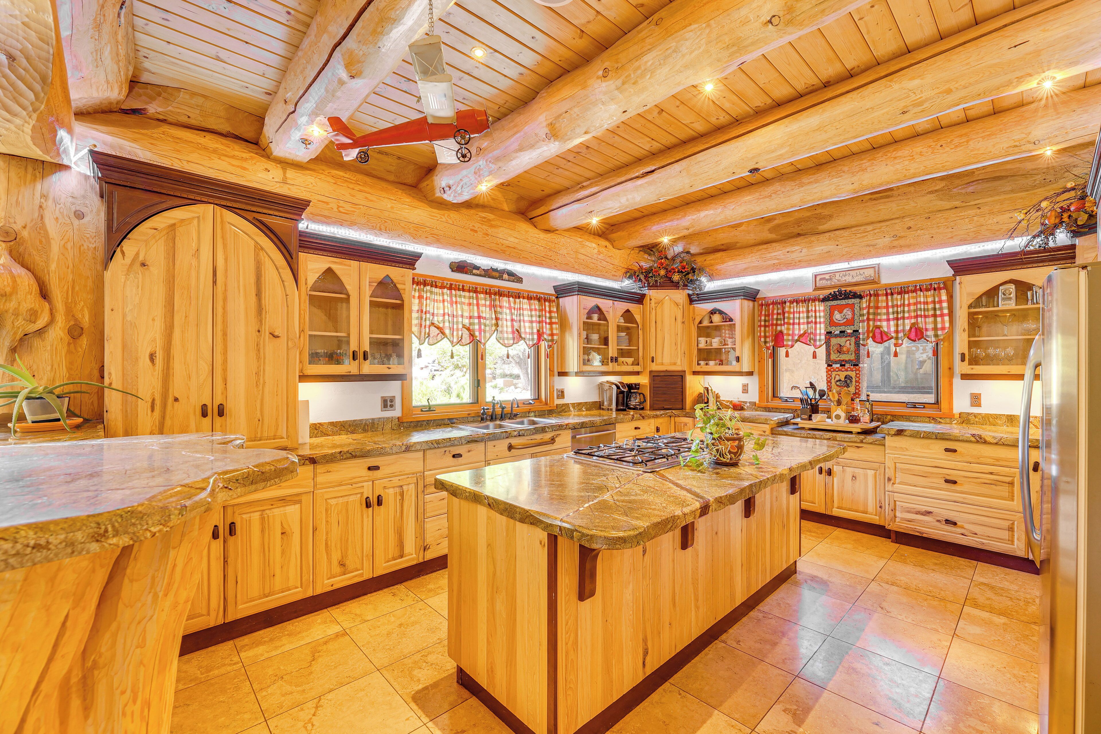 Una cocina amplia con armarios de madera, una isla grande y un techo alto con vigas a la vista.
