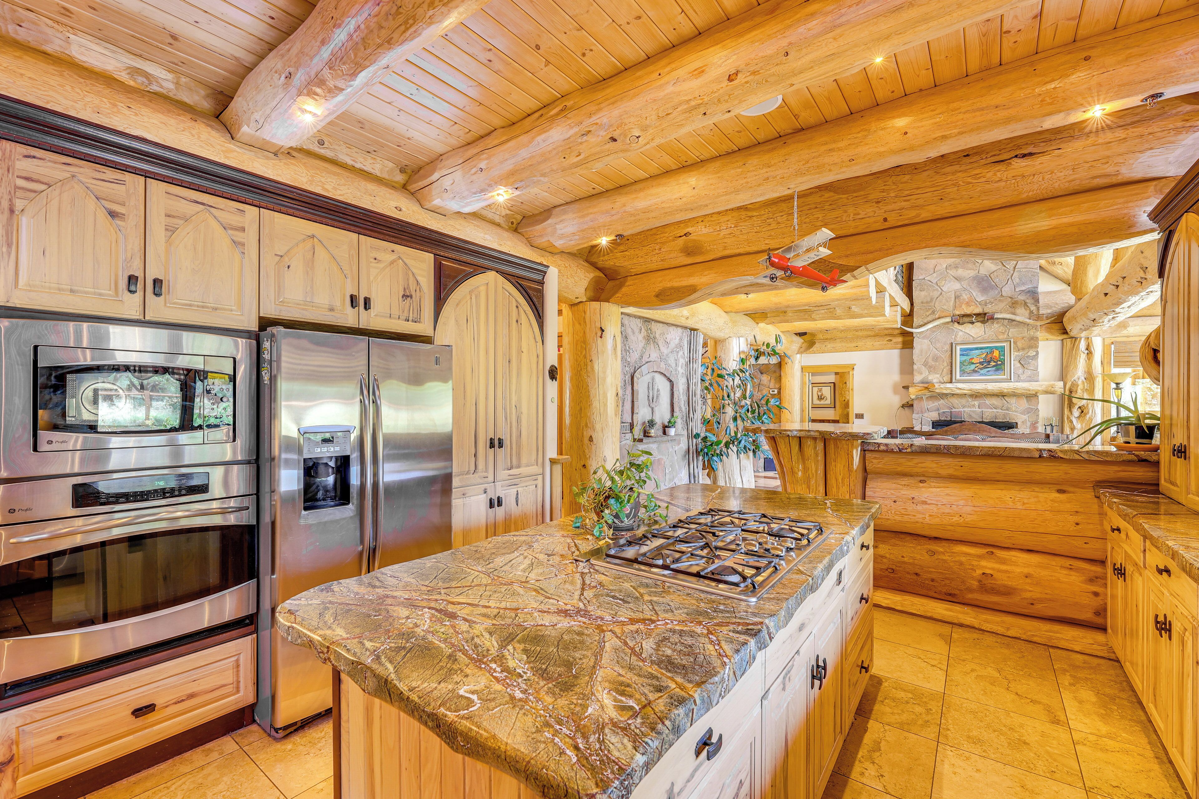 A spacious kitchen with wooden cabinets, stainless steel appliances, and a large island.